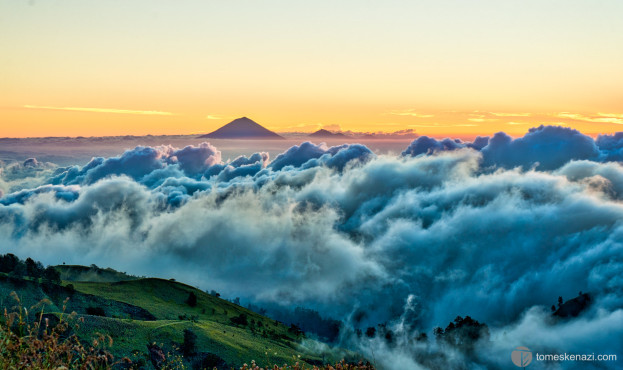 Sunrise from Rinjani volcano crater rim, view of Mount Agung & Batur in a sea of clouds.
